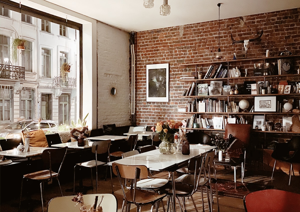 Warm café interior with greenery and a sunny window